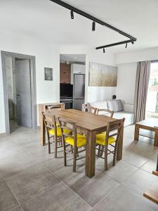 eine Küche und ein Esszimmer mit einem Holztisch und Stühlen in der Unterkunft Andes Apartments in Ioannina