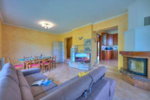 - un salon avec un canapé et une cheminée dans l'établissement Il Sole Di Mirasole - Happy Rentals, à Leggiuno