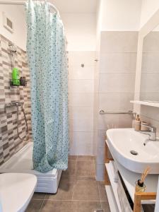 a bathroom with a shower curtain and a sink at AZUR Apartment in Timişoara