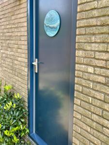 una puerta con una puerta azul con una ventana en ella en BBBoekelo appartement en Boekelo