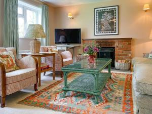 a living room with a green coffee table and a fireplace at Club Cottage in Dummer