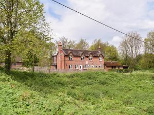 an old brick house on a hill in a field at Club Cottage in Dummer