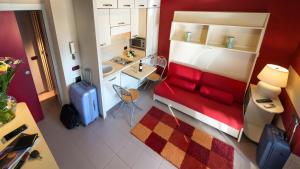 a living room with a red couch and a kitchen at Dimora in Alba in Alba