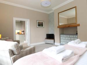 sypialnia z 2 łóżkami, kanapą i lustrem w obiekcie Bethby Beck Apartment Keswick w mieście Keswick