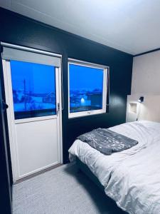 1 dormitorio con 1 cama y puerta con ventana en Holiday home with sauna in the Arctic Caribbean, Tromsø, en Tromsø