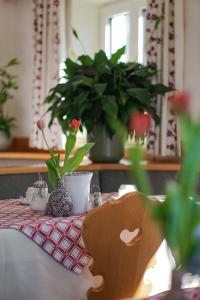 a table with a table cloth with a vase of flowers at Oberwirtshof in Rifiano