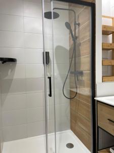 W łazience znajduje się prysznic ze szklanymi drzwiami. w obiekcie La Maison du Clocher w mieście Saint-Émilion