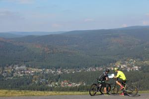 two people riding bikes on a hill with a view at Wellness Apartment Josefina - Free Grotta Spa wellness in Harrachov