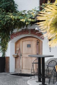 a table in front of a building with a wooden door at Oberwirtshof in Rifiano