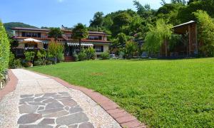 a house with a stone walkway in front of a yard at Agriturismo La Carreccia in Luni