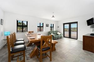 a dining room and living room with a table and chairs at Cottage 345 - Oughterard in Oughterard