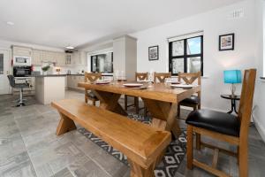 een keuken en eetkamer met een houten tafel en stoelen bij Cottage 345 - Oughterard in Oughterard