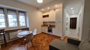 uma cozinha com armários brancos e uma mesa e cadeiras em Silver Apartments - Orientarium,Aquapark Fala & Park em Lódź