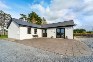 a detached house with a patio in front of it at Cottage 345 - Oughterard in Oughterard