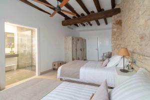 1 dormitorio con 2 camas y pared de piedra en Casa de ensueño en Almatret, en Riba-roja d'Ebre
