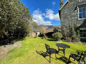 a table and chairs in the yard of a house at Bethby Beck Apartment Keswick at The Lairbeck in Keswick +8 photos