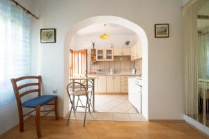 uma cozinha com um arco e uma mesa e cadeiras em Studio Apartman Ema 2 em Gornji Karin