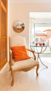 a chair with an orange pillow and a table at Z&Olé in Torremolinos
