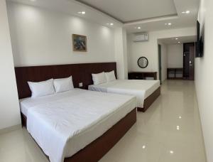 1 Schlafzimmer mit 2 Betten und weißer Bettwäsche in der Unterkunft FELIZ VILLA NHA TRANG in Nha Trang