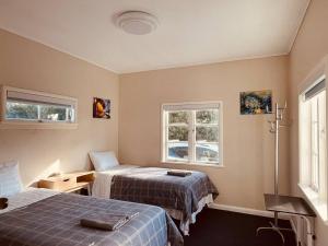 a room with two beds and two windows at Amber Hill A in Pukekohe East