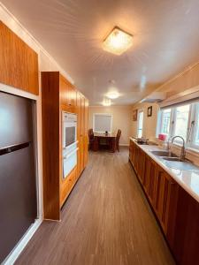 a kitchen with wooden cabinets and a sink and a table at Amber Hill A in Pukekohe East