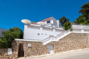 a white house with a stone wall at Villa BONA VISTA in Son Bou