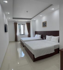 ein Hotelzimmer mit 2 Betten und einem TV in der Unterkunft FELIZ VILLA NHA TRANG in Nha Trang