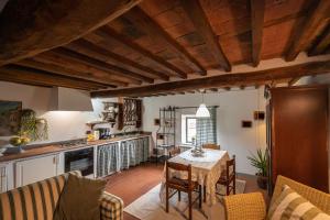 a kitchen and living room with a table and chairs at La Colombaia in Massa e Cozzile