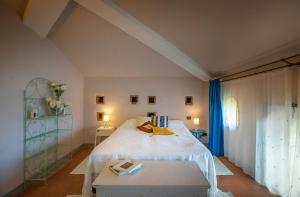 een slaapkamer met een wit bed en een tafel bij La Colombaia in Massa e Cozzile