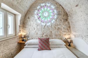 1 dormitorio con 1 cama con pared de piedra en Il Violino e Il Sassofono, en Ceglie Messapica