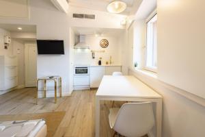 a kitchen with a white table and chairs in a room at Santa Croce Top by Mmega in Florence +8 photos