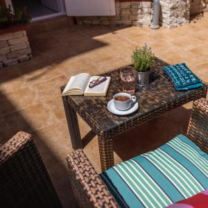 einen Tisch mit einem Buch und einer Tasse Kaffee in der Unterkunft Bed and breakfast Ciao Bella in Veli Lošinj