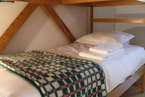 a bunk bed with a blanket on top of it at HI Guarda - Pousada de Juventude in Guarda