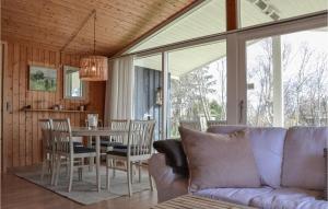 ein Wohnzimmer mit einem Sofa und einem Tisch mit Stühlen in der Unterkunft Cozy Home In Tisvildeleje With Wifi in Tisvildeleje