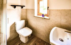 a bathroom with a toilet and a sink and a window at Awesome Home In Wejherowo With Kitchenette in Wejherowo