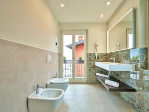 y baño con 2 lavabos, aseo y espejo. en Piccolo Hotel, en Garda