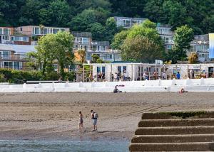 a group of people standing on the beach at Millendreath Beach Resort in Looe