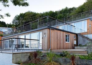 a house with a large balcony on the side of it at Millendreath Beach Resort in Looe