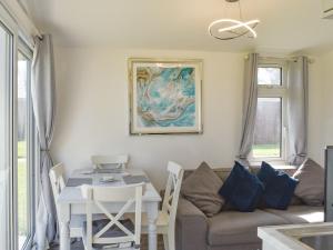 a living room with a couch and a table at Bluebell Lodge in Saint Merryn