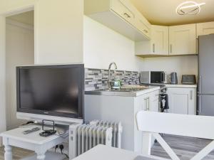 a kitchen with a large flat screen tv on a table at Bluebell Lodge in Saint Merryn