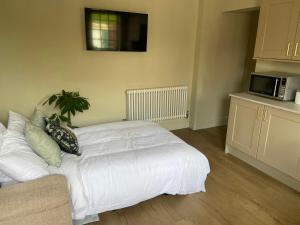 a bedroom with a white bed and a microwave at Cosy small cottage in Wirral Merseyside with kitchen 