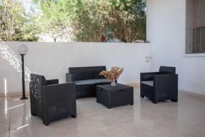 a patio with two chairs and a couch and a table at Villetta Aria Prima in Torre Lapillo
