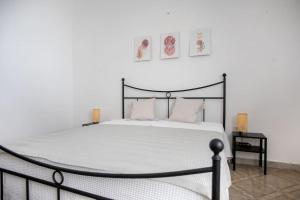a bedroom with a large bed with white sheets and pillows at Villetta Aria Prima in Torre Lapillo