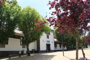 Un edificio blanco con árboles delante. en HI Guarda - Pousada de Juventude, en Guarda