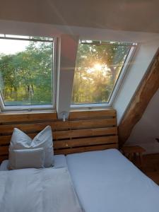 VersmoldにあるZum Heuerling Ferienwohung Leinenstube mit Saunaのベッドルーム1室(ベッド1台、窓2つ付)