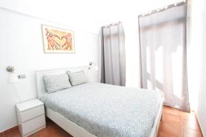 - une chambre blanche avec un lit et une fenêtre dans l'établissement Apartmento bonito con terraza grande, à Mogán