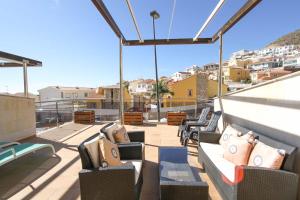 d'un balcon sur le toit avec des chaises et des tables. dans l'établissement Apartmento bonito con terraza grande, à Mogán