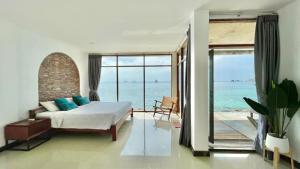 a bedroom with a bed and a view of the ocean at P.D. Beach Resort in Koh Tao