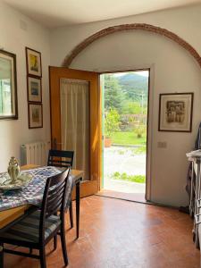 uma sala de jantar com uma mesa e uma porta de vidro em 'Il Casale di Giova' Tuscan Farmhouse em Lucca