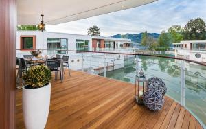 een huis met een terras met uitzicht op het water bij Deltapark Vitalresort Seevillen in Thun